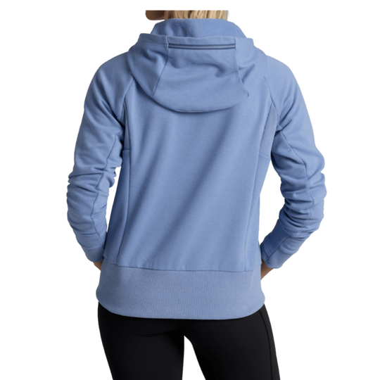 A person shown from the back wearing a light blue hooded sweatshirt and black leggings against a plain white studio background.