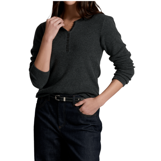 A woman wearing a dark charcoal gray long-sleeve henley sweater and dark blue jeans with a black belt, shown from the neck down against a plain white background.