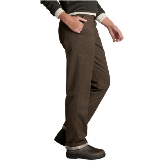 A person wearing dark brown work pants with a dark ribbed sweater and dark work boots, shown from the waist down against a plain white background.