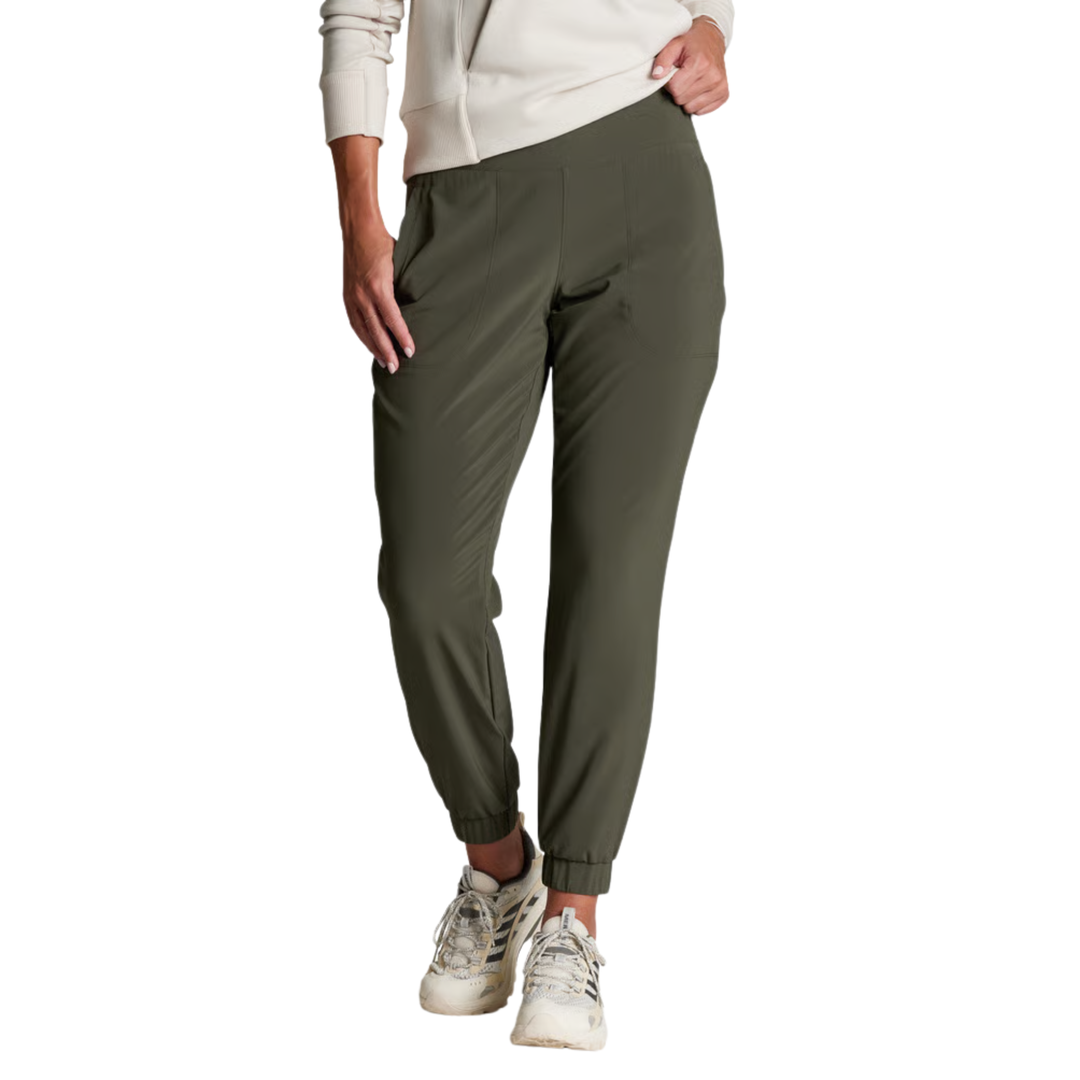 A person wearing olive green jogger-style pants with a white sweatshirt and white sneakers, shown from the waist down on a plain white background.