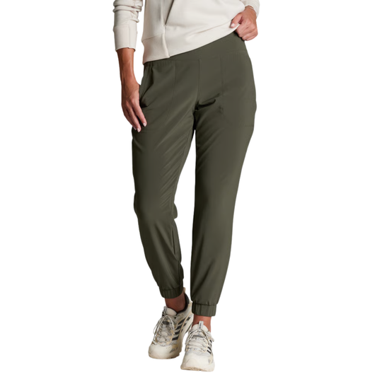 A person wearing olive green jogger-style pants with a white sweatshirt and white sneakers, shown from the waist down on a plain white background.