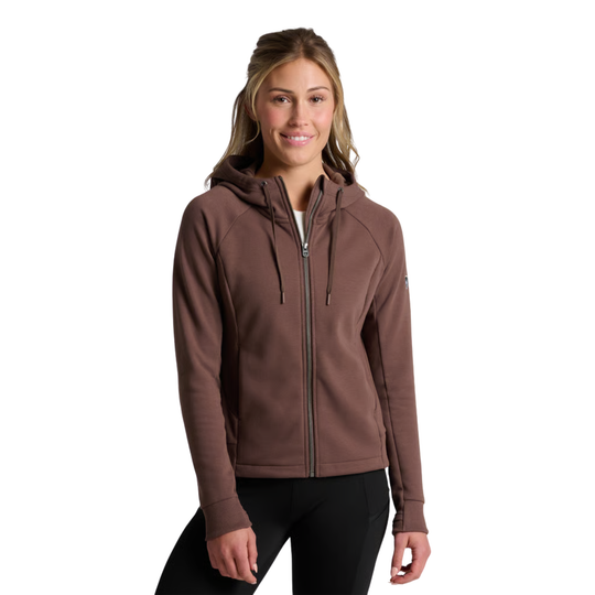 A woman wearing a brown full-zip hooded sweatshirt and black pants, standing against a plain white background.