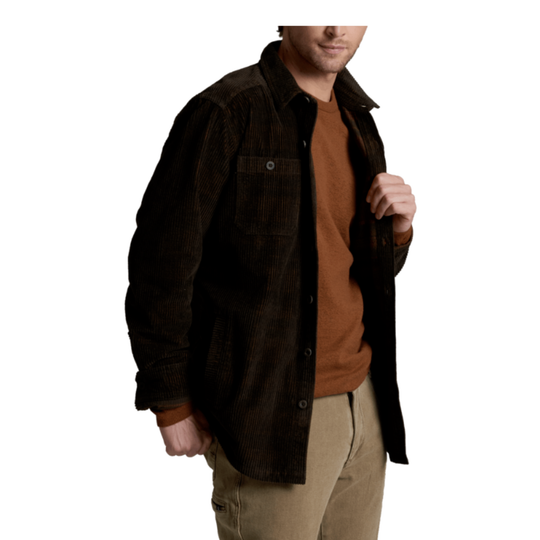 A man wearing a dark brown corduroy button-up shirt jacket over a rust-brown t-shirt and khaki pants, shown from the chest down against a plain white background.