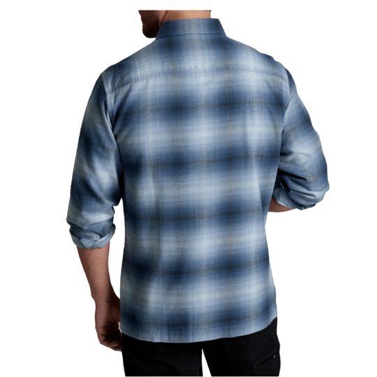 A man shown from the back wearing a long-sleeve plaid button-up shirt in shades of blue, gray, and white, paired with black pants against a plain white background.