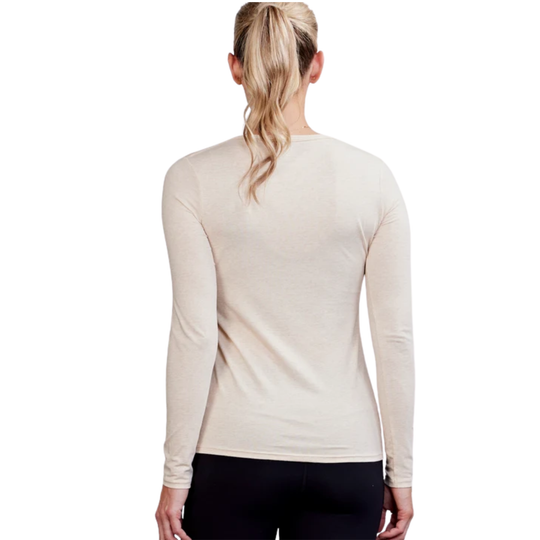 A woman viewed from the back wearing a fitted long-sleeve crew-neck top in a light warm cream color, paired with black bottoms, against a plain white background.