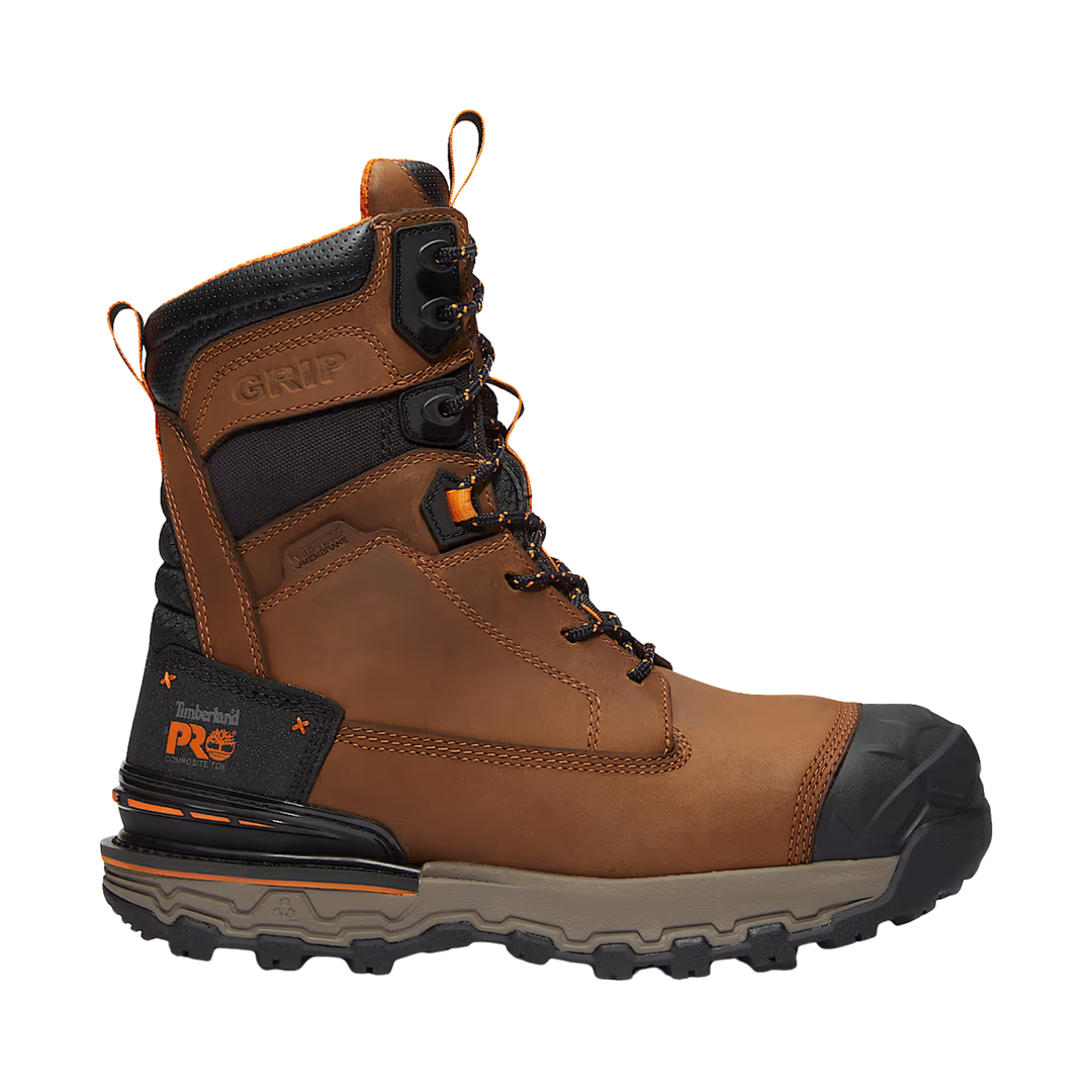 A brown leather work boot with black protective toe cap, collar, and heel, featuring a gray midsole and orange accents on the side logo and pull tabs, shown against a plain white background.