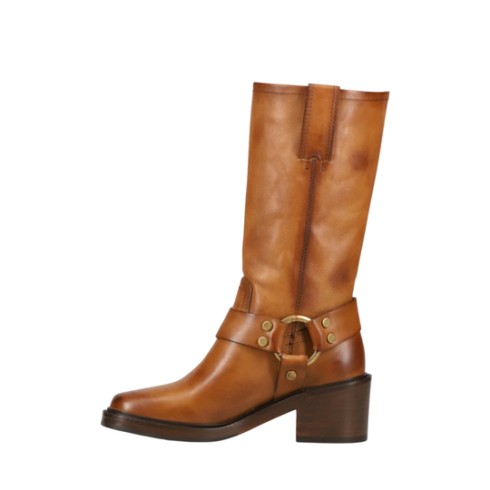 A mid-calf brown leather boot with a block heel, a decorative strap across the instep featuring brass-tone rivets and a buckle, and a pull zipper at the top, shown against a plain white background.
