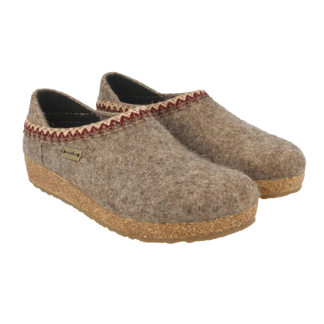 A pair of women's slip-on felt house shoes in a warm taupe-brown color, featuring a decorative red and beige zigzag trim along the collar and a natural cork sole.