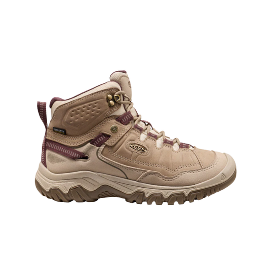 A mid-cut hiking boot by Keen in a light tan/beige colorway with dark plum purple accents on the laces, trim, and pull tabs, set against a plain white background.