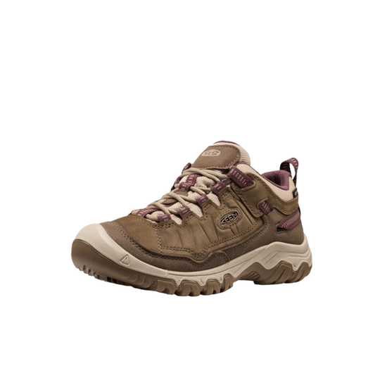 A single Keen brand mid-height hiking shoe in brown suede and synthetic materials, featuring brown laces, a beige toe cap and midsole, and a small purple accent near the heel, shown against a plain white background.