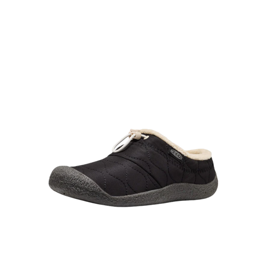 A single black slip-on mule shoe with a quilted upper, a light beige fleece lining, and a dark gray textured sole, shown against a plain white background.