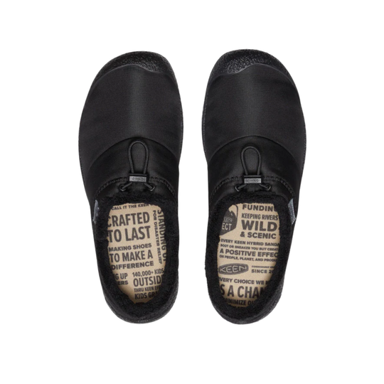 A pair of black slip-on clogs shown from a top-down view on a plain white background. The soles display printed text including 'CRAFTED TO LAST' and 'FUNDING WILD & SCENIC'.