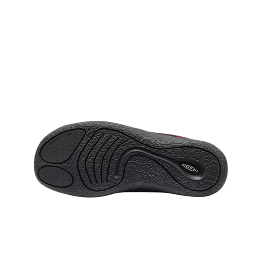 A single slip-on slipper with a red and black plaid pattern on the upper, a black sole, and black laces, shown against a plain white background.