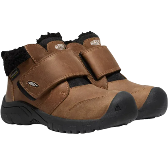 A pair of Keen Kids outdoor boots in brown leather with black fleece lining and black soles, featuring hook-and-loop strap closures.
