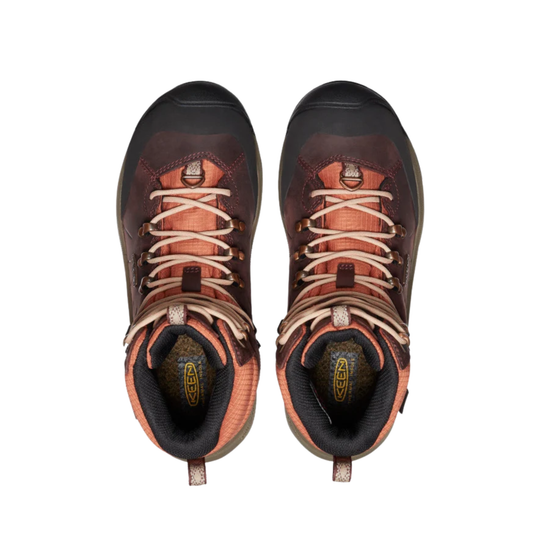A pair of Keen mid-height hiking boots shown from a top-down view, featuring a dark brown and rust-orange leather upper with beige laces and a black toe cap, set against a plain white background.