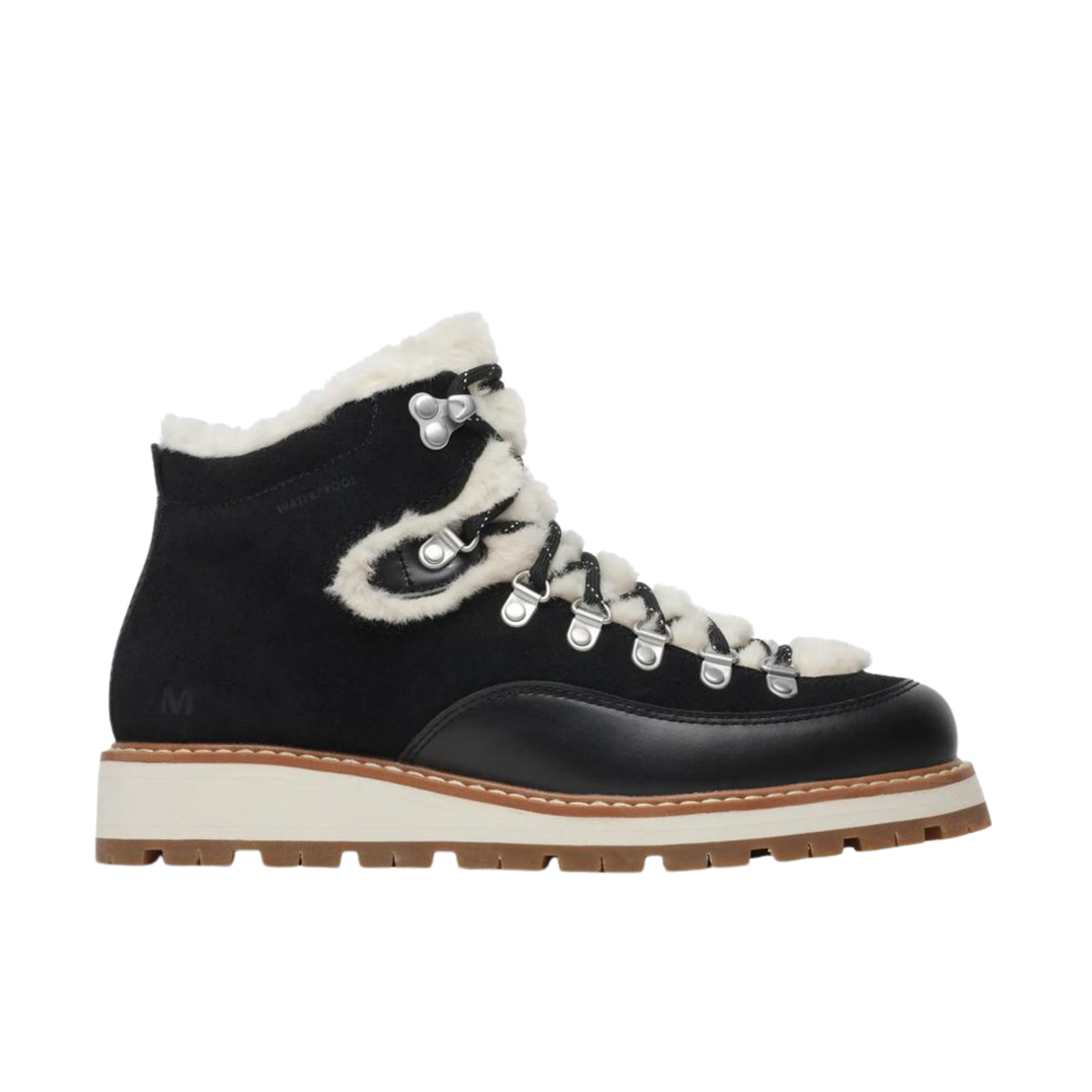 A black suede and leather ankle boot with white shearling-style lining, white laces, silver metal eyelets, and a thick off-white midsole with a brown outsole, shown from a side profile on a white background.