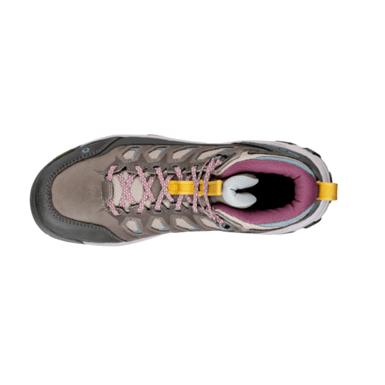 A top-down view of a hiking boot in gray suede and synthetic materials, featuring pink patterned laces, a yellow pull tab, and a pink inner lining.