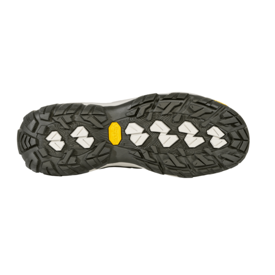 The outsole of a hiking shoe, showing a black Vibram tread pattern with white geometric lugs and a small yellow Vibram logo in the center, isolated on a white background.