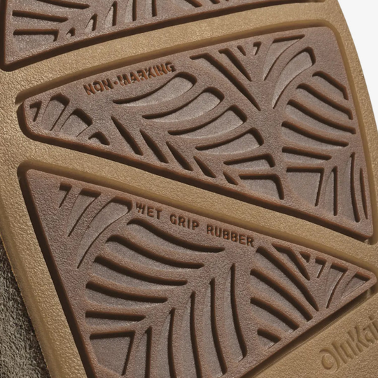 Close-up of a brown shoe sole showing textured rubber sections labeled 'NON-SCUFFING' and 'WET GRIP RUBBER', with part of the brand name 'Onikuma' visible at the bottom right.