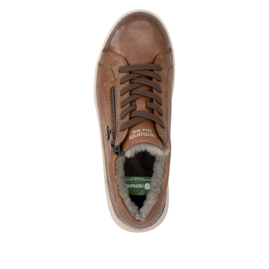 A top-down view of a Remonte brown leather sneaker with a side zipper, brown laces, and a gray faux-fur lining visible at the collar, set against a plain white background.