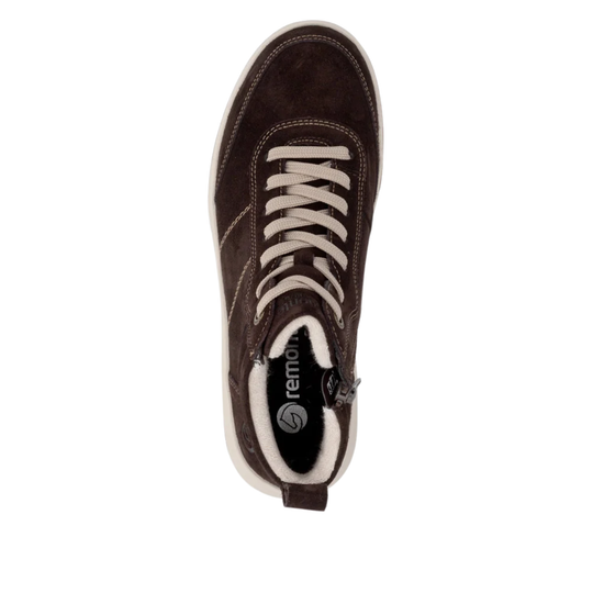 A single dark brown suede sneaker shown from a top-down view on a white background. The shoe features cream-colored laces, a cream midsole, and a black interior lining with the 'remonte' brand logo visible.