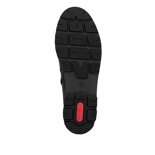 A top-down view of a black shoe sole with a textured tread pattern and a small red heel accent containing the brand name 'rieker'.