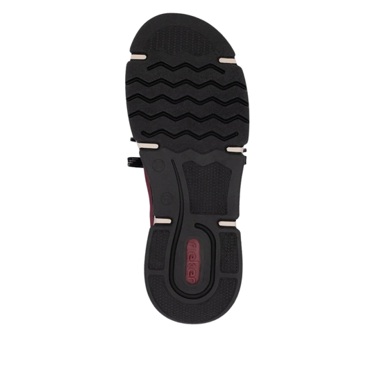 The black rubber outsole of a shoe, showing the tread pattern and a red 'Rieker' logo on the heel, isolated on a white background.