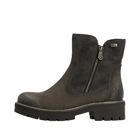 A dark gray suede and leather ankle boot with a side zipper, chunky lug sole, and a small metal brand plaque on the collar, shown against a plain white background.