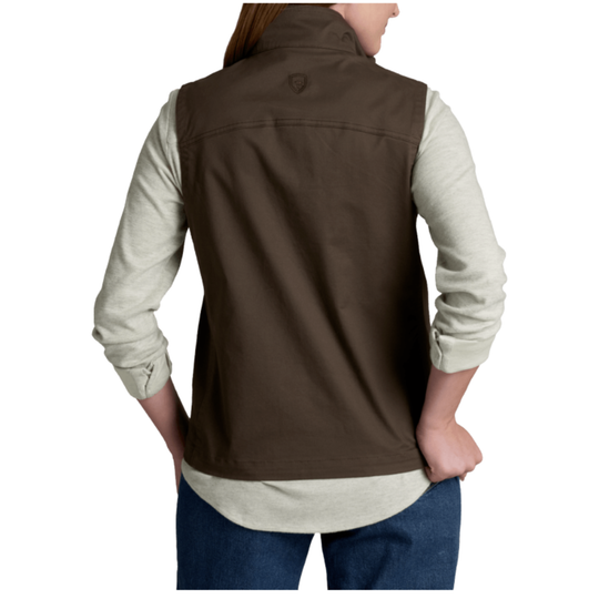 A woman shown from the back wearing a brown sleeveless vest over a light heather gray long-sleeve shirt and blue jeans, against a plain white studio background.