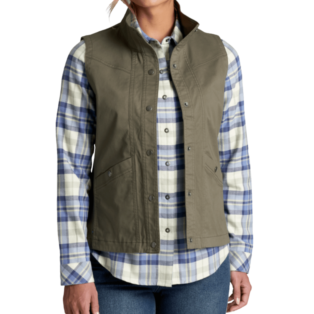 A woman wearing an olive green sleeveless button-front vest over a blue and white plaid button-up shirt, paired with blue jeans, against a plain white background.