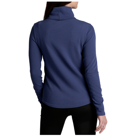 A woman shown from the back wearing a ribbed long-sleeve mock neck top in a medium blue color, paired with black pants, against a plain white background.