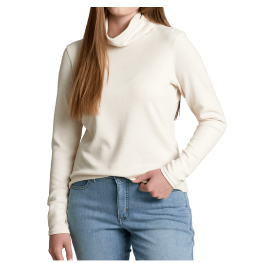 A woman wearing a cream-colored ribbed turtleneck sweater and light blue jeans, shown from the neck down against a plain white background.