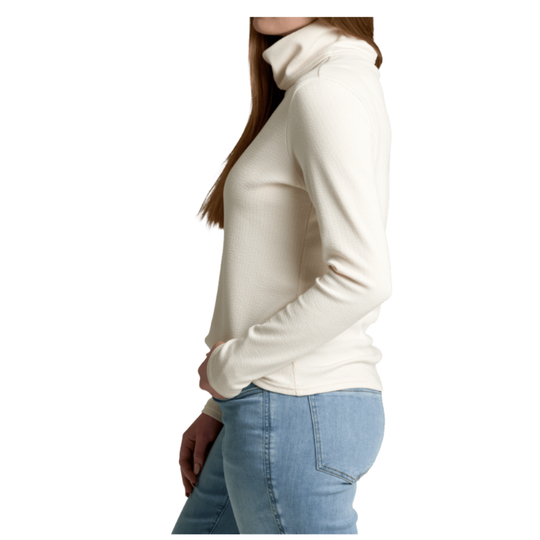 A woman shown from the side wearing a fitted cream turtleneck sweater and light blue jeans against a plain white background.