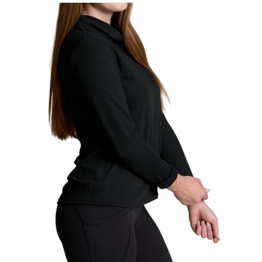 A woman wearing a black long-sleeve mock neck athletic top and black leggings, shown from the side against a plain white background.