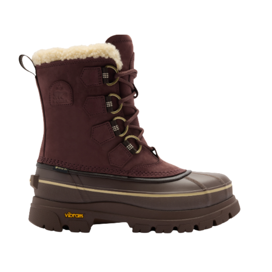 A single burgundy winter boot with a thick brown Vibram sole, featuring a cream-colored shearling lining at the collar, lace-up front, and gold-tone hardware, shown against a plain white background.