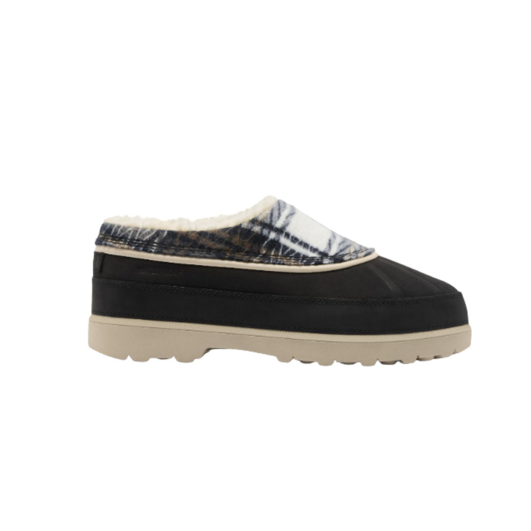 A single slip-on mule shoe shown in profile against a plain white background. The shoe has a black upper, a cream-colored textured sole, and a patterned collar featuring a white base with a dark blue-gray abstract design.