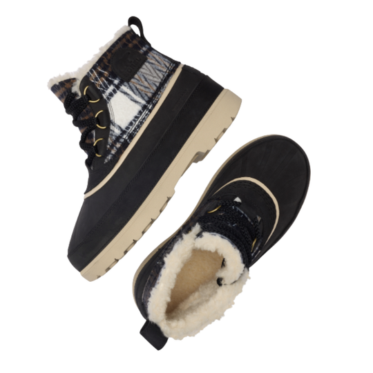 A pair of women's mid-calf winter boots with a black suede-like upper, a plaid patterned side panel, black laces, and a thick cream-colored sole and plush cream sherpa lining.