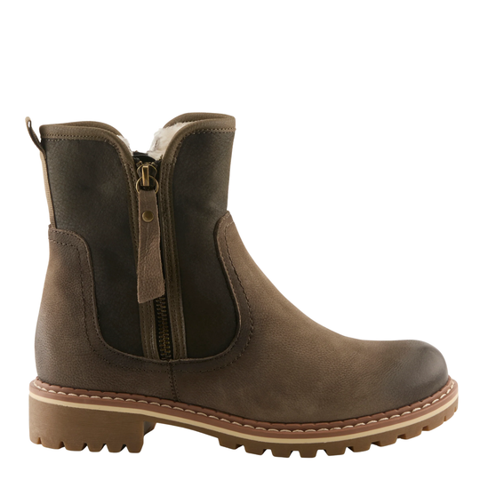 A dark olive leather Chelsea-style ankle boot with a side zipper, elastic side panels, and a chunky lug sole, shown from a side profile on a white background.
