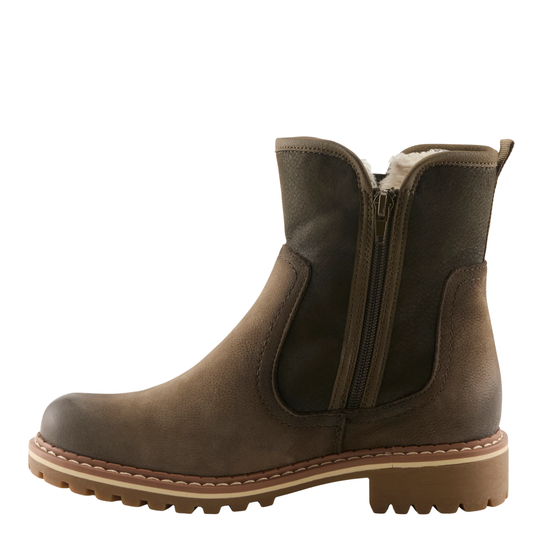 A dark olive leather Chelsea-style ankle boot with a side zipper, elastic side panels, and a chunky lug sole, shown from a side profile on a white background.