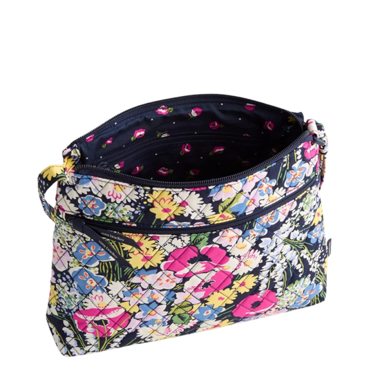 A zippered cosmetic pouch with a colorful floral print on a black background, shown open against a plain white background.