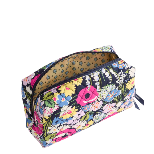 A rectangular zippered cosmetic pouch with a vibrant multicolor floral print on a black background, shown open to reveal a tan patterned lining.
