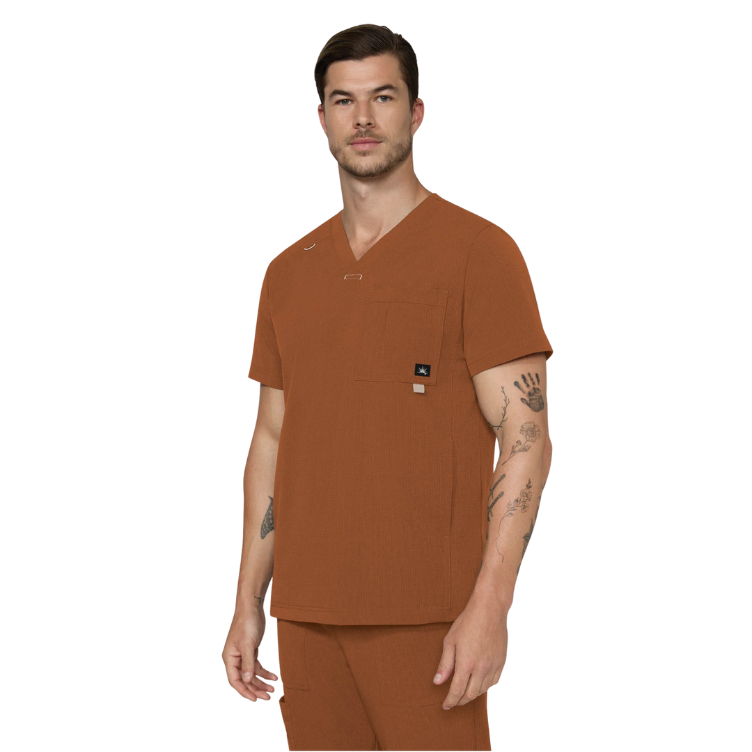 Man wearing a copper scrub top and pants on a white background