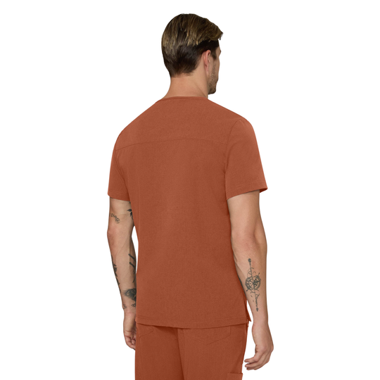A man viewed from the back wearing a rust-orange short-sleeve scrub top and matching scrub pants against a plain white background.