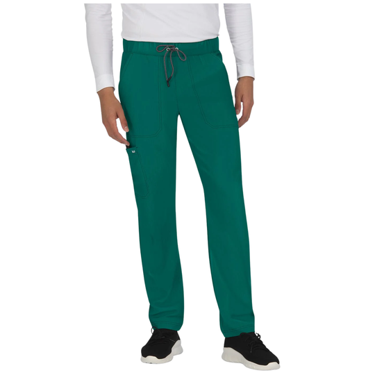 A person wearing teal scrub pants with a drawstring waist, shown from the chest down against a plain white studio background.