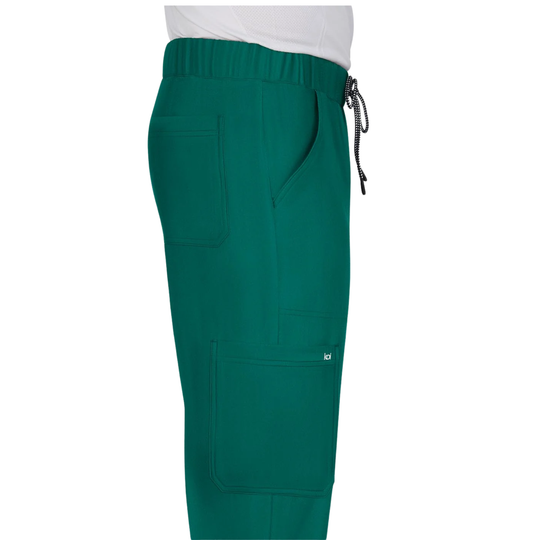 Green scrub pants with an elastic waistband, black drawstring, side pockets, and cargo pockets, shown on a model wearing a white top against a white background.