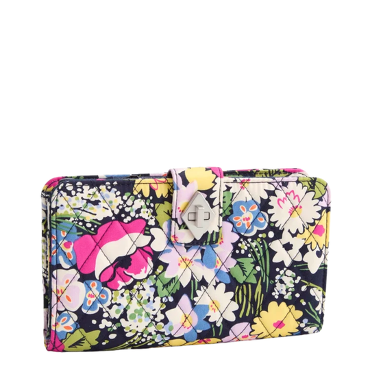 A rectangular clutch wallet with a vibrant multicolor floral print on a dark navy background, featuring a silver-tone metal turn-lock clasp closure.