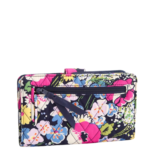 A rectangular quilted clutch bag featuring a vibrant multicolor floral print on a black background, with a black zipper and strap detail.