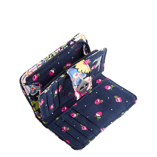 An open navy blue canvas wallet with a colorful floral and cartoon print, showing its interior card slots and zippered compartments on a white background.