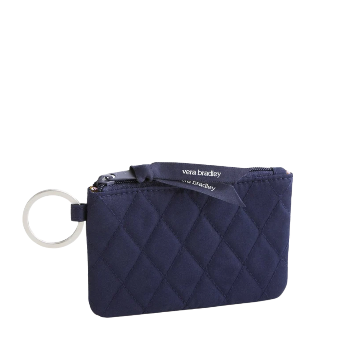 A navy blue quilted zip pouch with a silver-tone key ring and a navy ribbon label that reads 'vera bradley'.