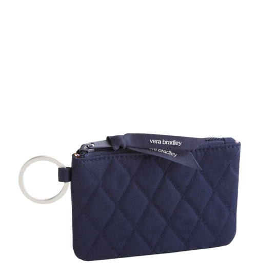 A navy blue quilted zip pouch with a silver-tone key ring and a navy ribbon label that reads 'vera bradley'.